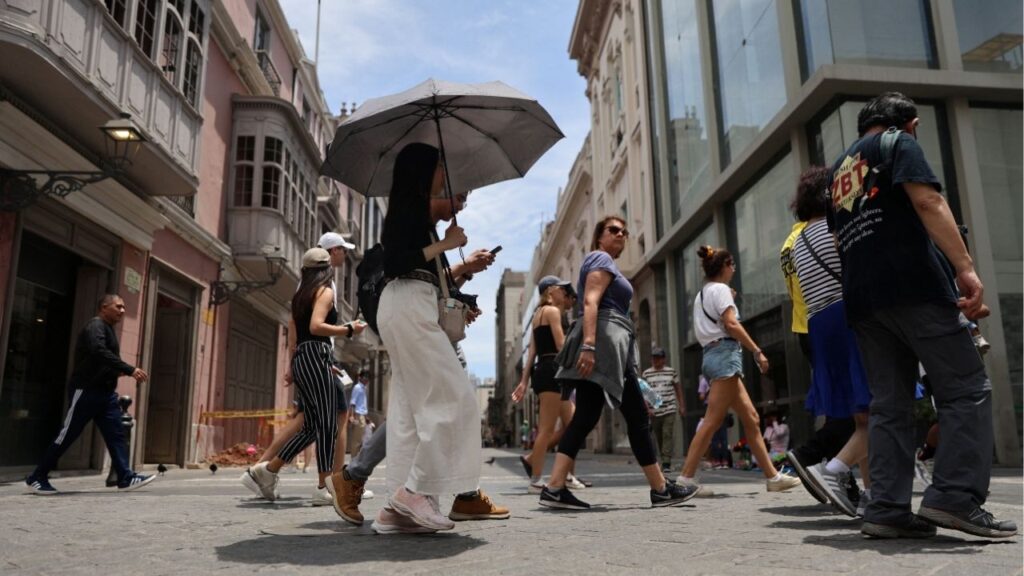 A woman walks through the streets of the downtown with an umbrella due to high temperatures, in Lima, Peru, February 25, 2024. (Reuters/Sebastian Castaneda)