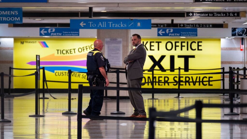 An Amtrak police officer speaks with a New York Police Department detective after a stabbing at Pennsylvania Station in midtown Manhattan on Sunday, June 7, 2026. A man stabbed six people at the station on Sunday evening, seriously wounding one, according to city officials. (Dakota Santiago/The New York Times)