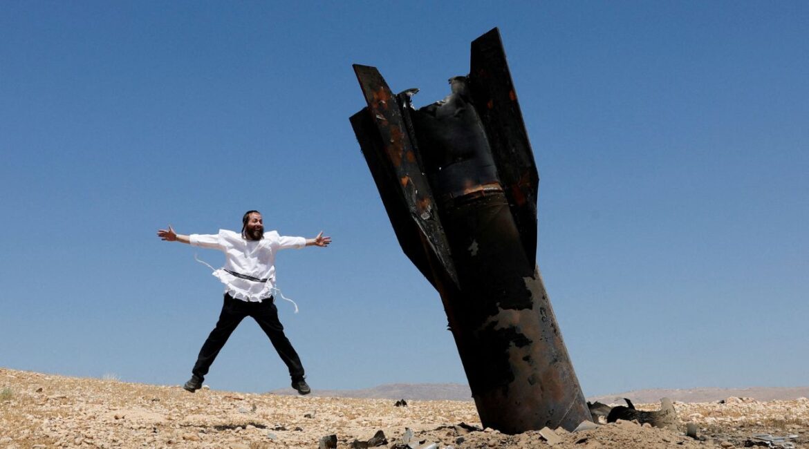 An Israeli ultra-Orthodox Jewish man reacts near a part of a missile protruding from the ground, following strikes from Iran, in the central Israeli-occupied West Bank, June 8, 2026. (Reuters/Ammar Awad)