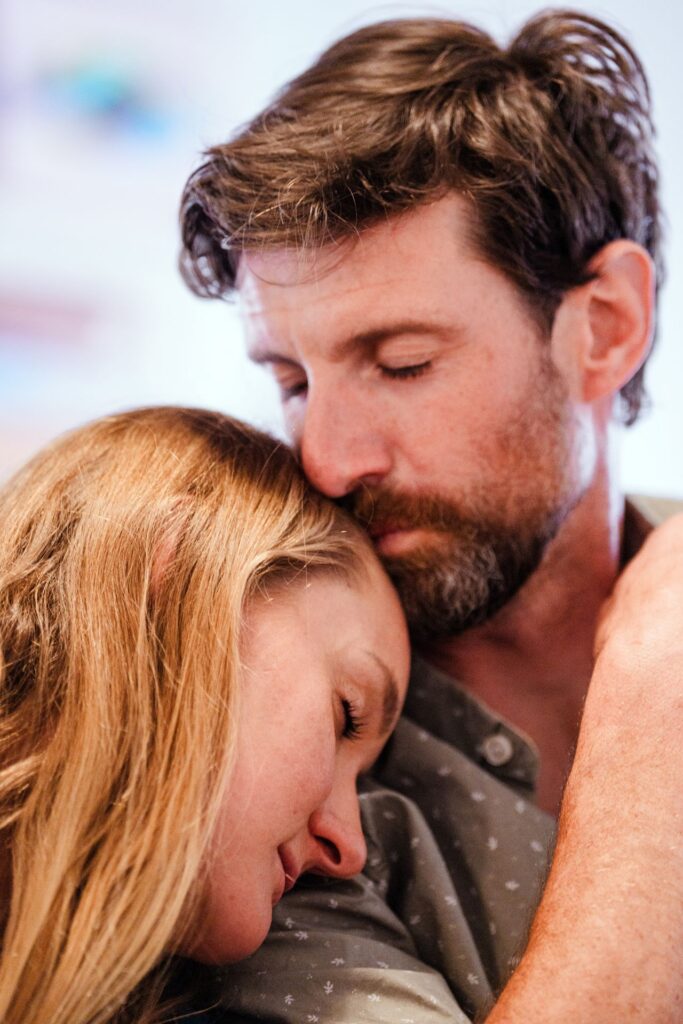 Image of a woman with blonde hair nuzzling with her bearded boyfriend