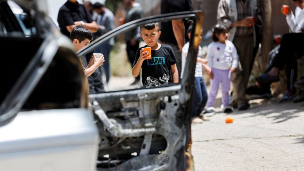 Children stand near a damaged car, which Palestinians say was burned by Israeli settlers,in Halhul near Hebron in the Israeli-occupied West Bank May 20, 2026. (Reuters File)