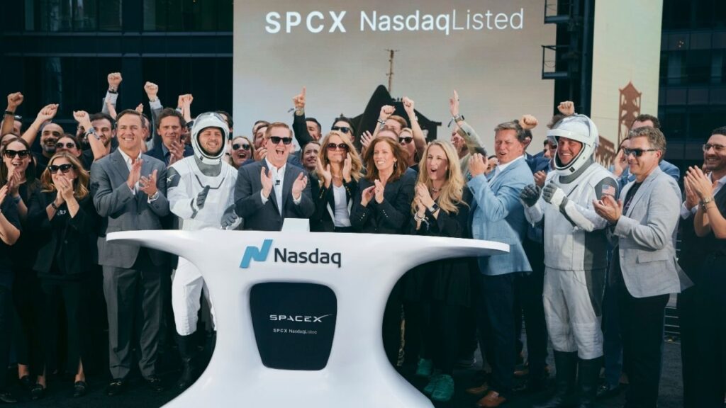 Executives and amployees of SpaceX, including the chief financial officer Bret Johnson, near center in sunglasses, and others dressed as astronauts, cheer the closing bell at the Nasdaq stock exchange in midtown Manhattan on Friday, June 12, 2026. SpaceX’s share price continued to surge on Monday, the company’s first full day of trading, adding to its sharp move higher on Friday after its record-breaking public listing. (Andres Kudacki/The New York Times)