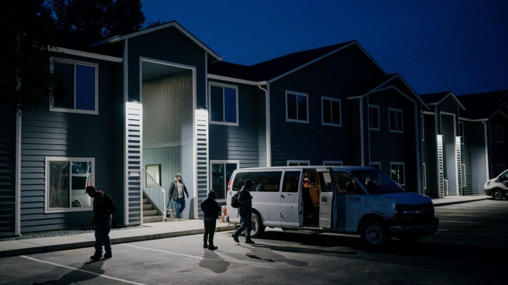 Early morning image of farmworkers loading up a van outside of an apartment complex before heading to work
