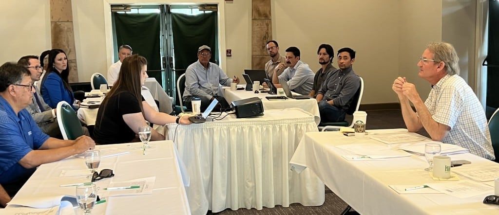 Image of farmers sitting around tables at a meeting