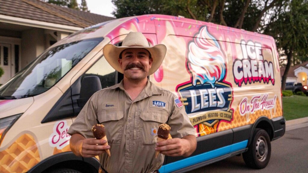 Image of a man in a khaki shirt and a cowboy hat holding an ice cream cone in each hand