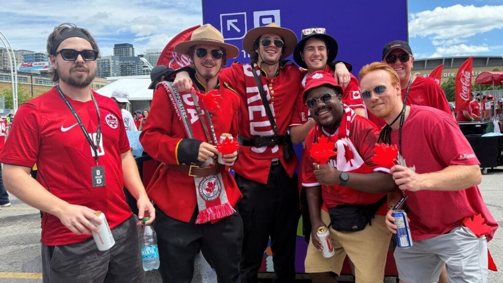 Liam Delaney poses for a group photo outside Toronto Stadium after going straight from work to catch a glimpse of the Canadian football team, ahead of the FIFA World Cup 2026 Group B opener between Canada and Bosnia and Herzegovina in Toronto, Ontario, Canada, June 12, 2026. Picture taken with a mobile phone. (Reuters/Kyaw Soe Oo)
