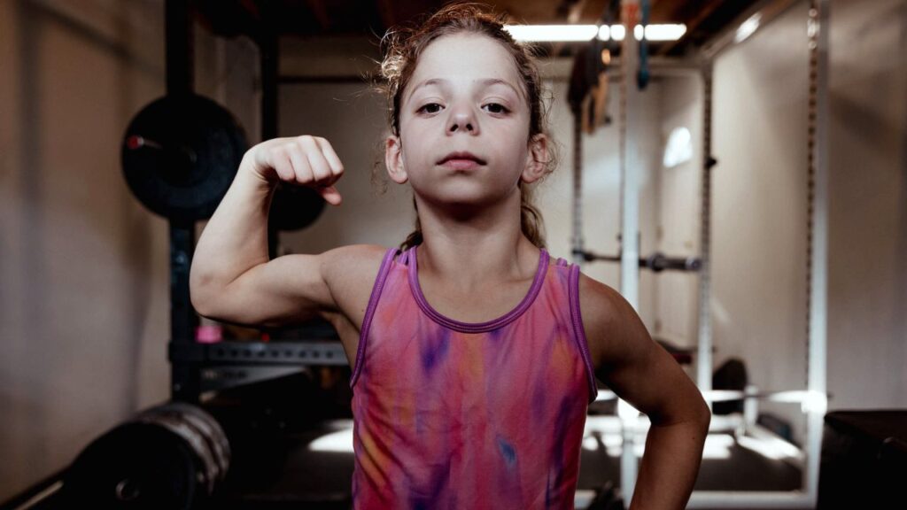 Lucy Milgrim, 10, at her home gym in Long Island, N.Y., on Sunday, May 17, 2026. For these kid fitness influencers, pumping iron can feel like play. (Laila Stevens/The New York Times)