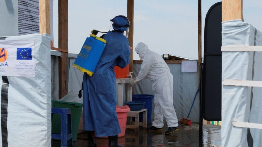 Medical workers dressed in personal protective equipment (PPE) disinfect and wash their hands at an Ebola treatment centre during a ceremony to present recovery certificates to patients at the Rwambara General Reference Hospital in Bunia, eastern Democratic Republic of Congo, June 16, 2026. (Reuters/Gradel Muyisa Mumbere)