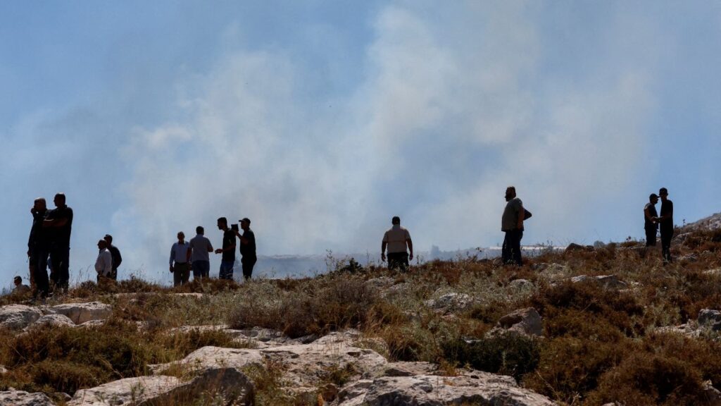 Palestinians observe smoke rising from a fire started by crowd control grenades thrown by Israeli troops, during a protest against a settlement near Hebron in the Israeli-occupied West Bank, June 9, 2026. (Reuters/Mussa Qawasma)