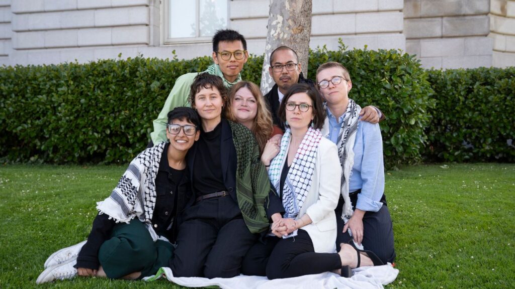 Protesters who were charged for blocking the Golden Gate Bridge sit together outside San Francisco Superior Courthouse in San Francisco, Calif., June 4, 2026. From left; Bhavika Anandpura, River Allen, Rocky Chau, Sara Cantor, Conrad de Jesus, Sarah Ferrell and Em Tillotson. (Minh Connors/The New York Times)