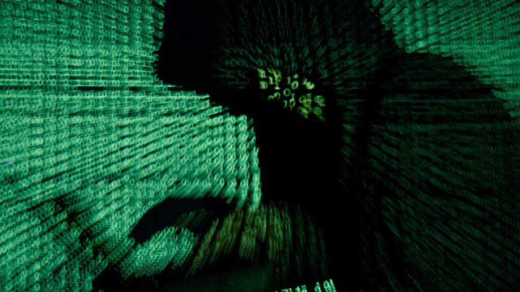 A man holds a laptop computer as cyber code is projected on him in this illustration picture created on May 13, 2017. (Reuters/File Photo)