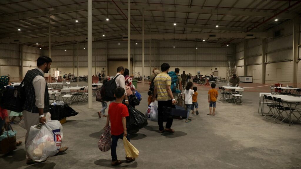 Special Immigrants from Afghanistan walk through the in-processing building after their evacuation at Camp As Sayliyah, Qatar, August 20, 2021. U.S. Army/Sgt. Jimmie Baker/Handout via Reuters