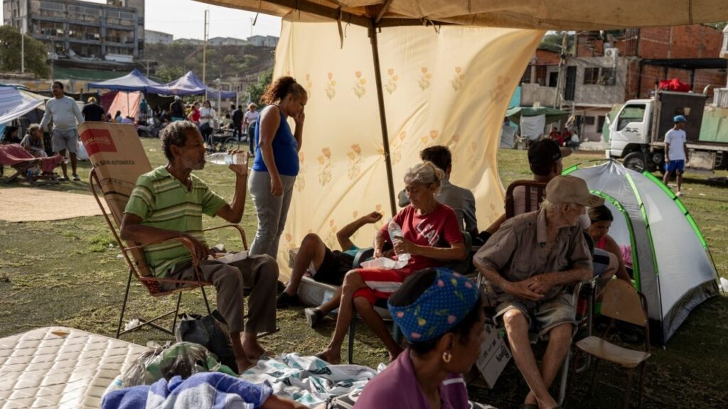 The Mayora family, whose home was destroyed in Wednesday’s earthquakes, sit under a tent at a baseball stadium in La Guaira, Venezuela, June 25, 2026. Twin earthquakes have left thousands homeless. Many others who are too afraid to sleep in their homes have taken to the streets. (Fabiola Ferrero/The New York Times)