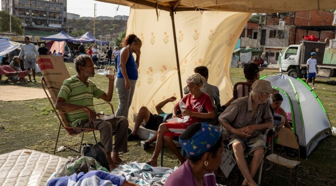 The Mayora family, whose home was destroyed in Wednesday’s earthquakes, sit under a tent at a baseball stadium in La Guaira, Venezuela, June 25, 2026. Twin earthquakes have left thousands homeless. Many others who are too afraid to sleep in their homes have taken to the streets. (Fabiola Ferrero/The New York Times)