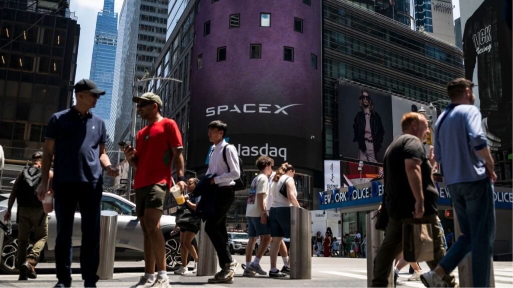 Protestors opposed to Elon Musk gather outside the headquarters of JPMorgan Chase in midtown Manhattan to mark the initial public offering of SpaceX on Friday, June 12, 2026. As Elon Musk became the world’s first trillionaire, workers are facing higher prices and fears of A.I.-driven job losses. (Andres Kudacki/The New York Times) The billboard at the Nasdaq stock exchange in Manhattan promotes the initial public offering of SpaceX on Friday, June 12, 2026. As Elon Musk became the world’s first trillionaire, workers are facing higher prices and fears of A.I.-driven job losses. (Karsten Moran/The New York Times)