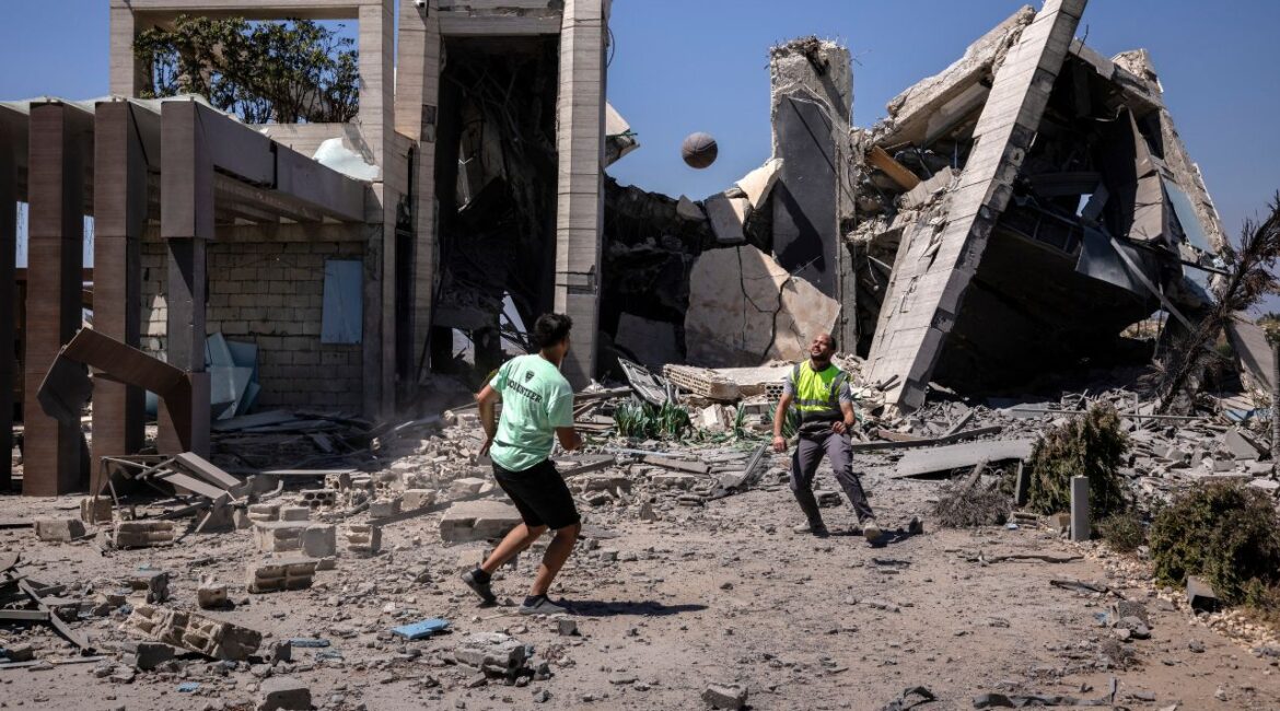 A Lebanese civil defense worker plays soccer with a civilian in front of a destroyed building in Qabrikha in southern Lebanon, where people have begun returning after a ceasefire was announced, on Tuesday, June 16, 2026. Israel has said its forces have been targeting the Iran-backed Hezbollah militia, and it has continued to launch strikes since the U.S.-Iran preliminary deal was announced over the weekend. (David Guttenfelder/The New York Times)