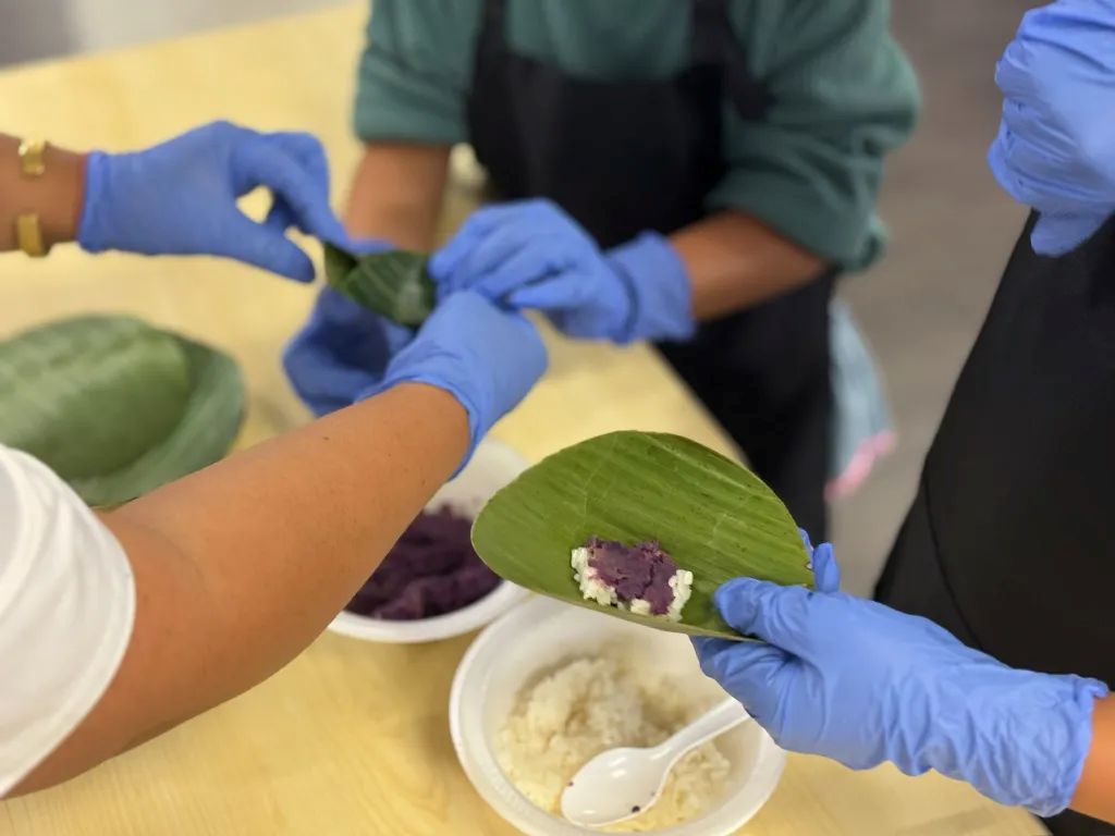 Images of cooking students wearing blue latex gloves filling banana leaves