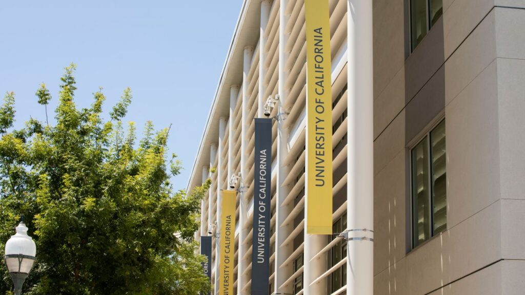 Image of UC California building in downtown Merced, California, with yellow banners hanging out front