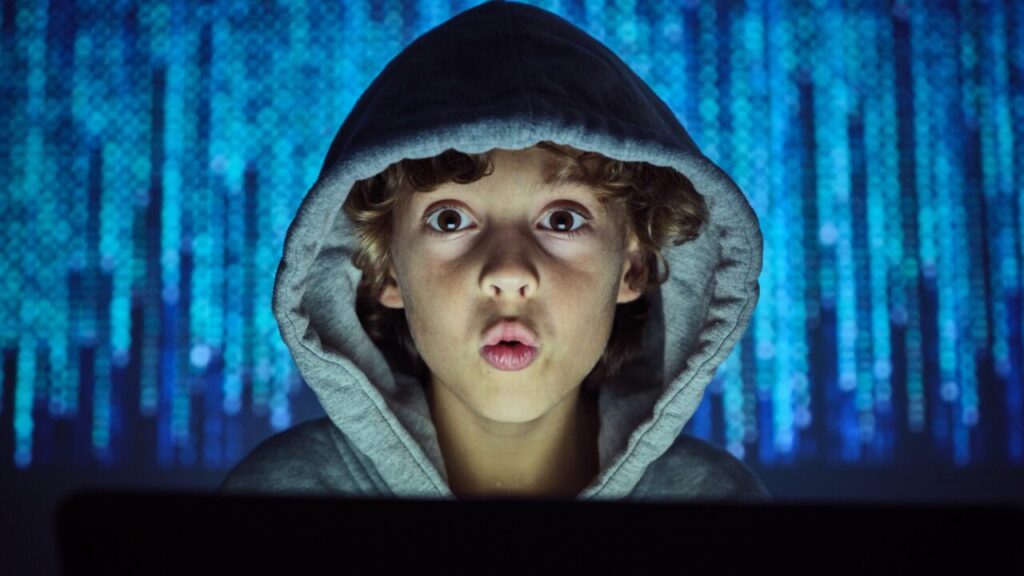 Image of a young boy in a hoody in a room illuminated by blue light