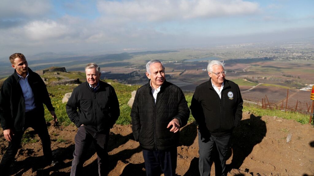 Image of Lindsey Graham, Benjamin Netanyahu, and other officials standing on a hill at the Israeli-Syrian border
