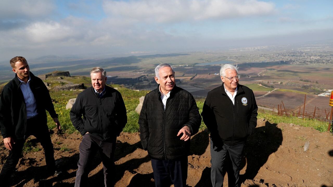 Image of Lindsey Graham, Benjamin Netanyahu, and other officials standing on a hill at the Israeli-Syrian border