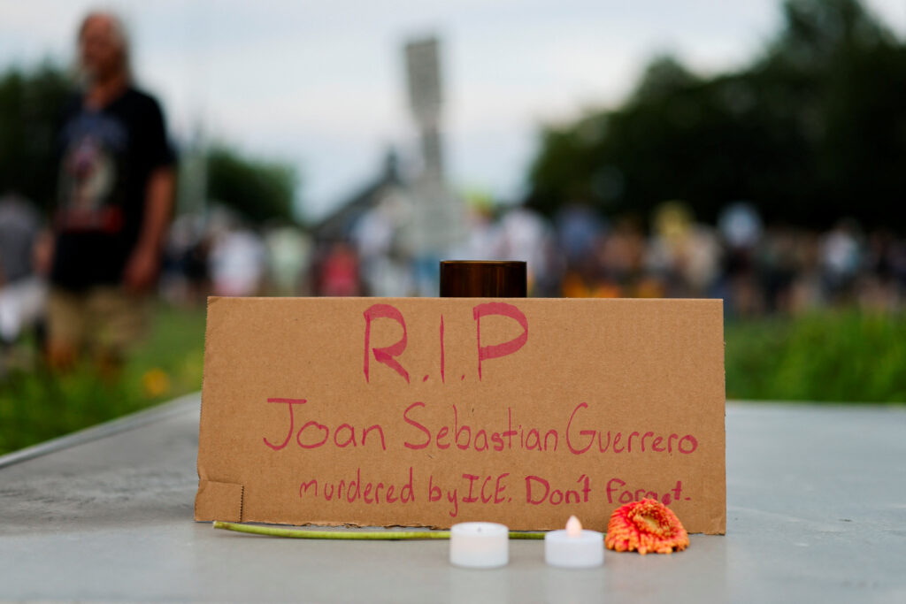 A handwritten cardboard memorial sign in the name of Joan Sebastian Guerrero is displayed during a candlelight memorial service at Mechanics Park, after a shooting involving U.S. Immigration and Customs Enforcement (ICE), in Biddeford, Maine, U.S., July 13, 2026. (Reuters/CJ Gunther)