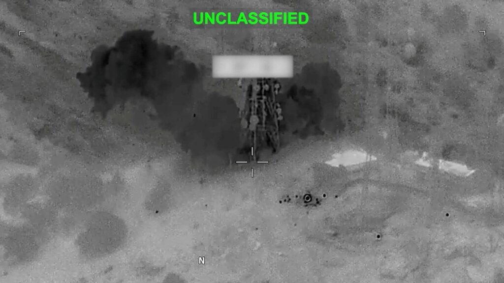 Image of smoke and debris rising on US military strikes on Iran and the word in green "Unclassified"