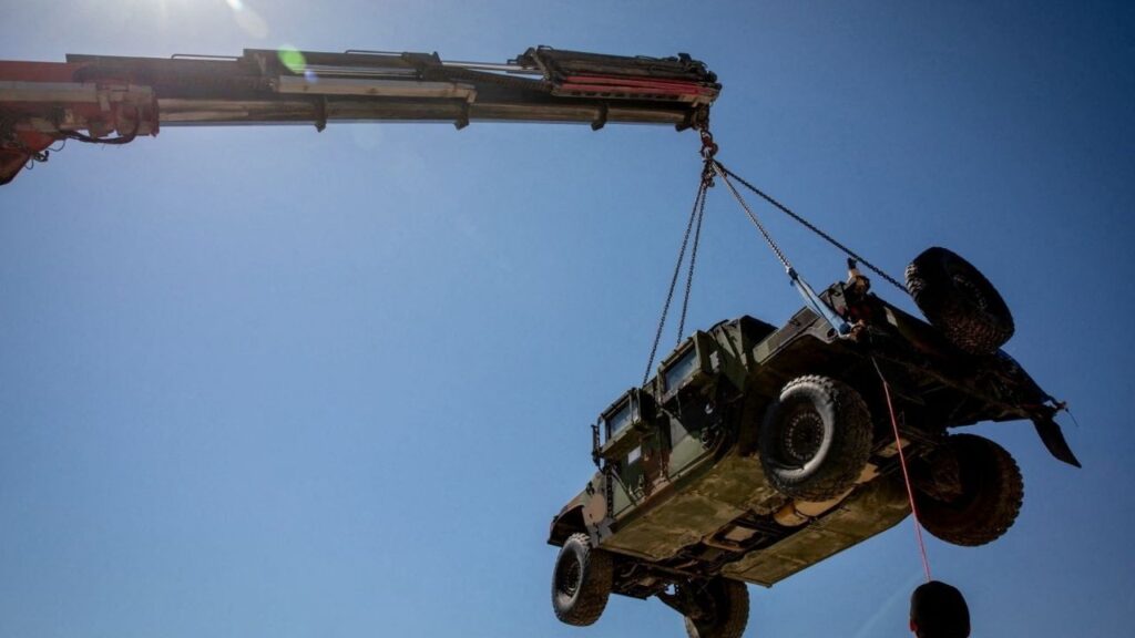 A crane hoists a tactical vehicle at the Logistics Support Area, in a location given as near Kerem Shalom, in this handout picture released June 30, 2026, by the Trump-appointed Board of Peace. Board of Peace/Handout via Reuters