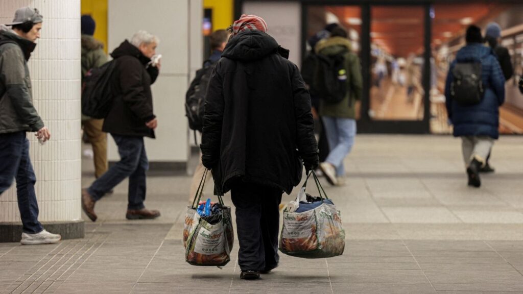 A man carries shopping bags at Penn Station in New York City, U.S., January 27, 2026. REUTERS/Jeenah Moon