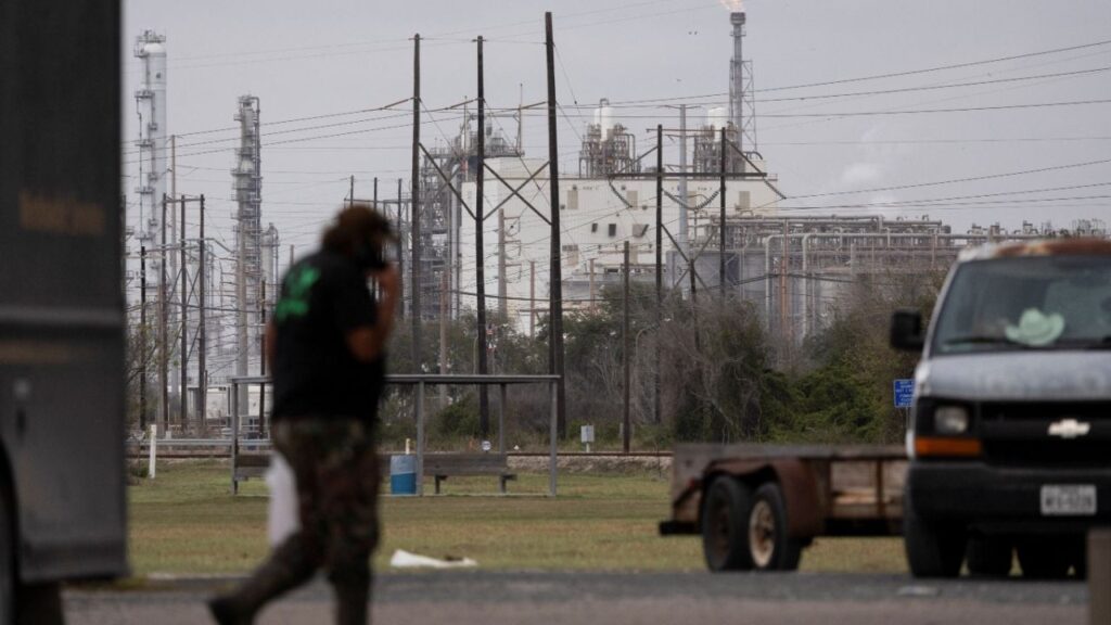A man passes by at an Exxon gas station as a flare stack burns in the distance at the Formosa Point Comfort Plant in Point Comfort, Texas, U.S., January 8, 2026. (Reuters File)