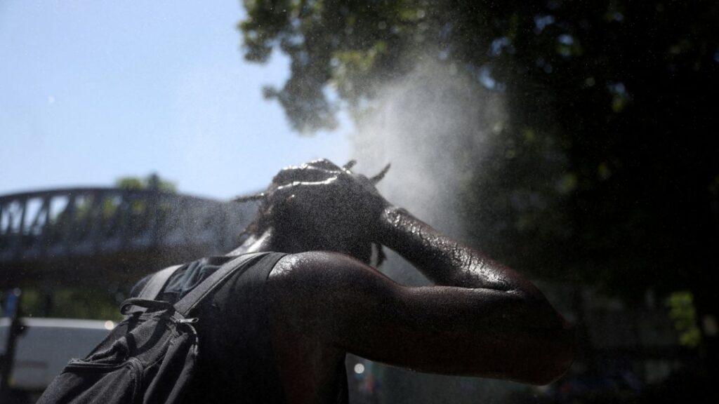 A person cools off at a water mister on a street in Paris as temperatures rise during a heatwave affecting a large part of France, June 22, 2026. (Reuters File)