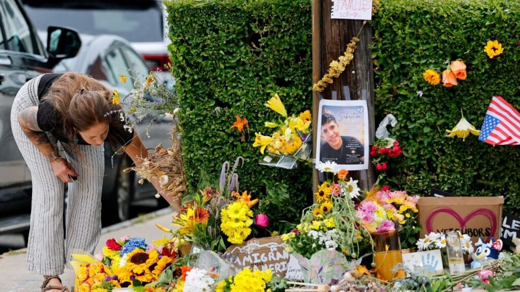 A woman bends over a makeshift street side memorial, a day after a U.S. Immigration and Customs Enforcement (ICE) agents fatally shot a driver, in Biddeford, Maine, U.S., July 14, 2026. (Reuters/CJ Gunther)