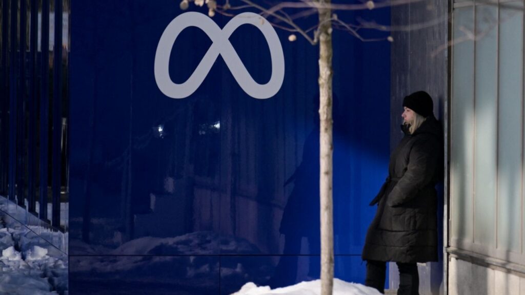 A woman stands near a Meta logo, January 20, 2026. (Reuters File)