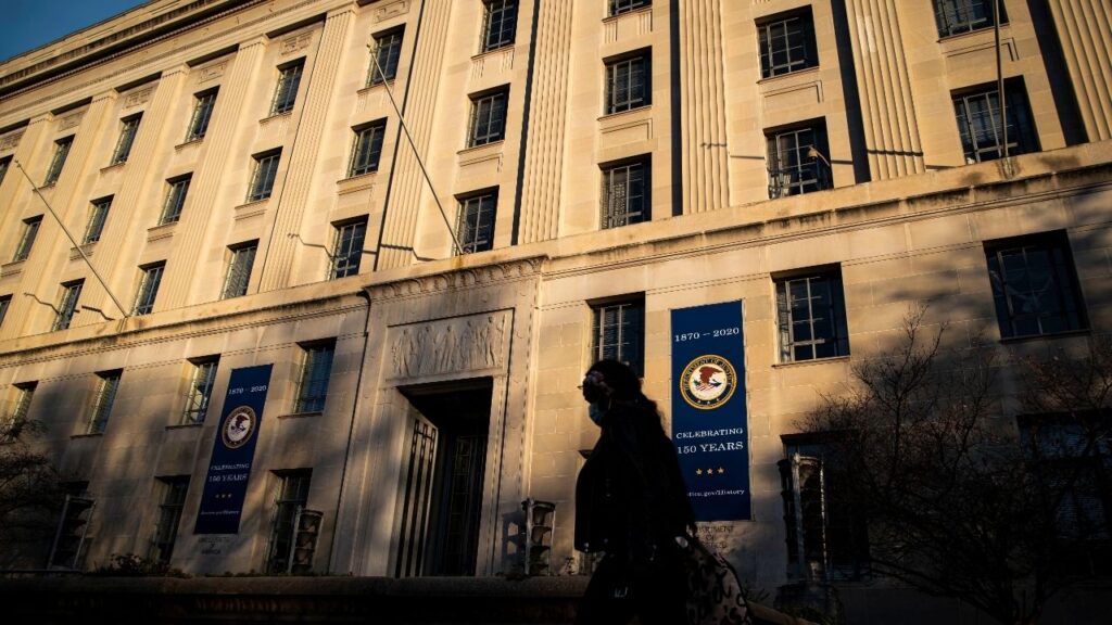 A woman walks past the U.S. Department of Justice Building, in Washington, U.S., December 15, 2020. REUTERS/Al Drago