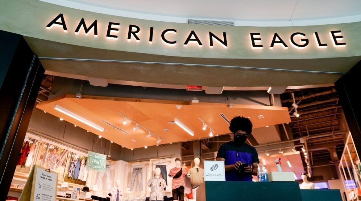 An American Eagle Outfitters employee waits for customers at a cleaning station outside a store in Arlington, Virginia, U.S., June 1, 2021. (Reuters File)