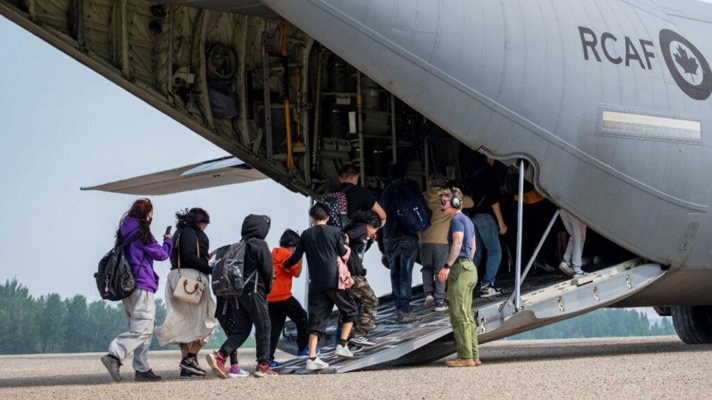 Canadian Armed Forces Corporal Rhiann Nicol assists residents onto a CC-130J Hercules transport aircraft during their evacuation due to wildfires in Fort Hope, Ontario, Canada July 19, 2026. (Master Corporal Natasha Punt/Canadian Armed Forces/Handout via Reuters)