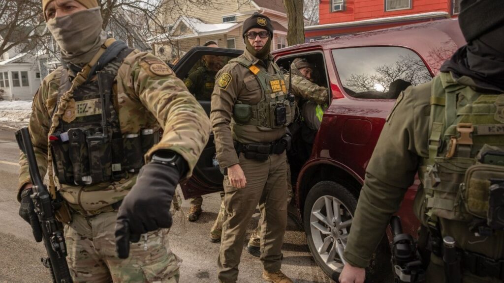 Federal agents try to pull an unidentified man from a vehicle to arrest him on a street in Minneapolis, Jan. 11, 2025. A federal judge on Monday, July 20, 2026, dismissed a Justice Department lawsuit challenging state and local policies in Minnesota that limit cooperation with immigration officials. (David Guttenfelder/The New York Times)