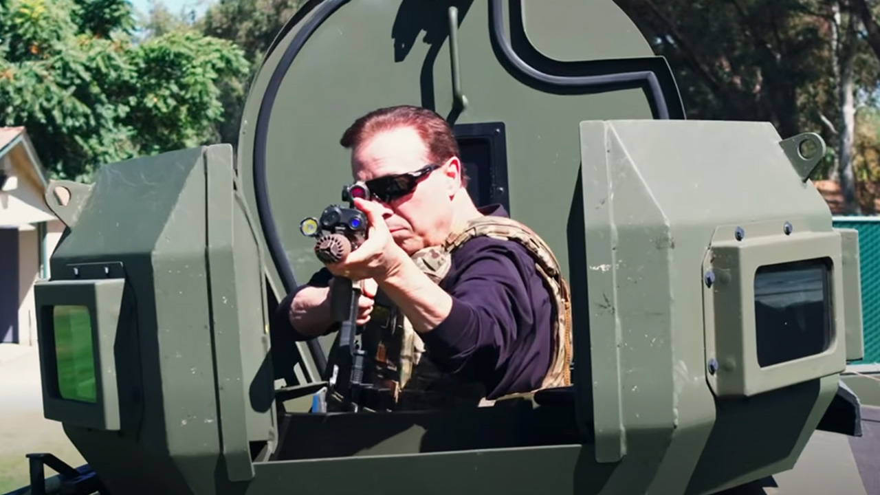 Image of Fresno County Supervior Garry Bredefeld pointing a high-powered gun from a SWAT vehicle,