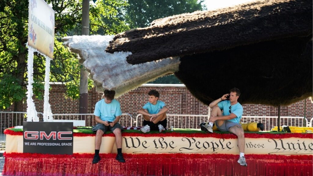 Employees with a float rental company sit under the shade of a bald eagle’s tail, after the parade was canceled due to extreme heat, in Philadelphia on Friday, July 3, 2026. A parade in Philadelphia, one of the largest in its history, was canceled on Friday, and the Great American State Fair on the National Mall in Washington closed for several hours amid extreme heat. (Rachel Wisniewski/The New York Times)