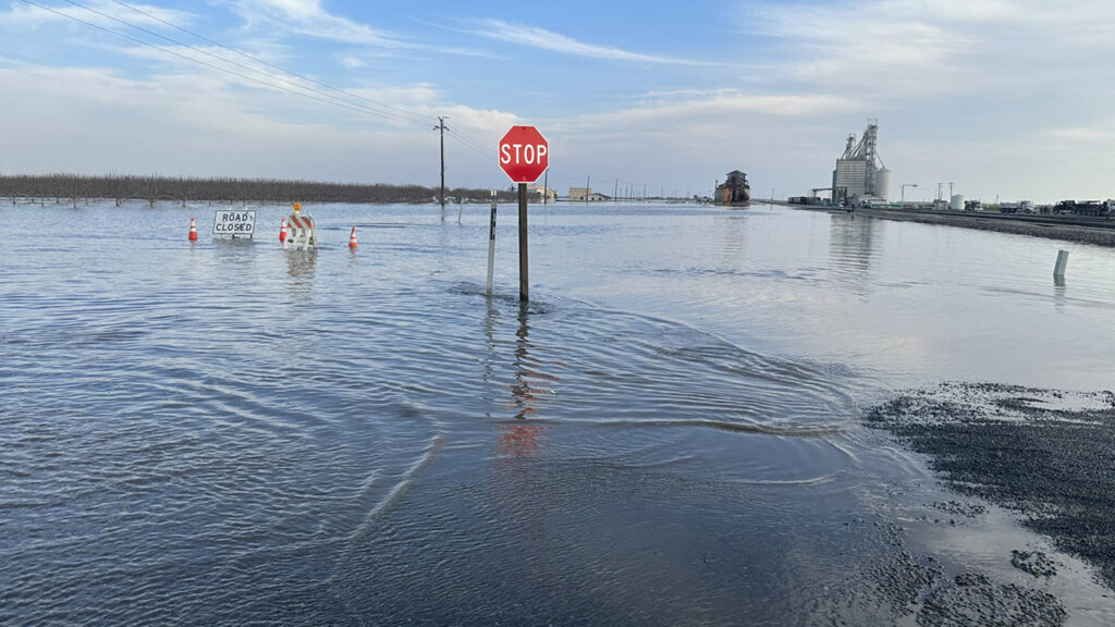 Image of a stop sign and flooded streets