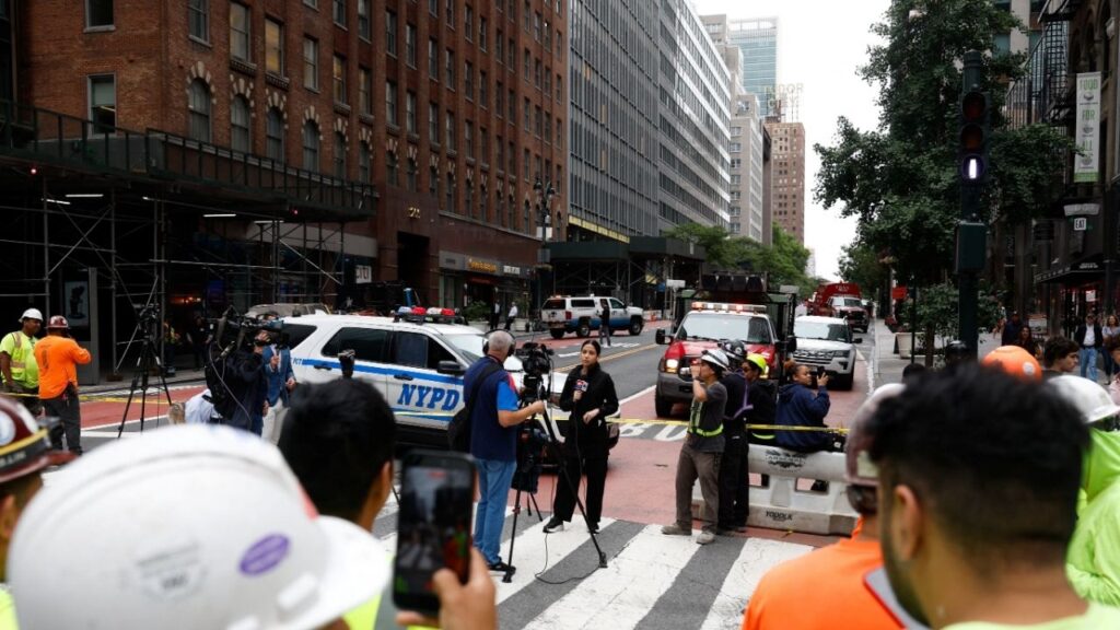 Members of the media work near a building on 42nd Street, which was reported to have structural issues, in New York City, U.S., July 7, 2026. REUTERS/Jordan Tovin