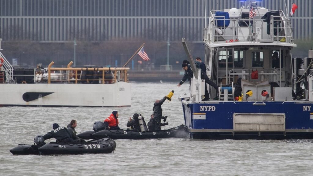 New York Police Department investigators are seen from Jersey City, N.J., during the search for evidence in the crash of a helicopter on the Hudson River, April 11, 2025. A tourist helicopter that crashed into the Hudson River last year, killing six, was most likely struck by a flock of geese before it fell, according to documents released on Thursday, July 16, 2026, by the National Transportation Safety Board. (Adam Gray/The New York Times)
