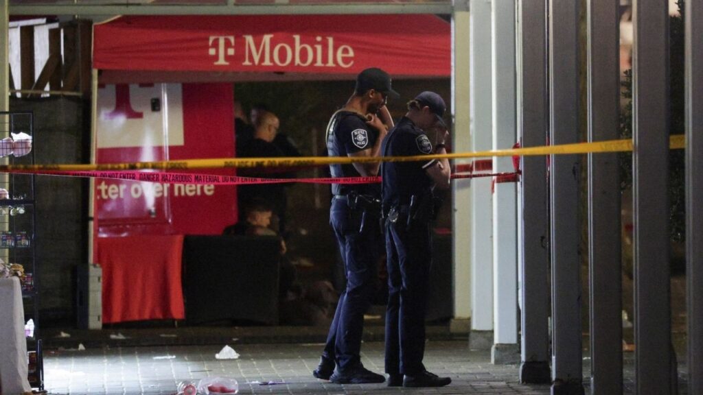 Police officers stand at a cordoned-off area after Seattle Police responded to what they described as a shooting with "multiple" victims at Seattle Center, which was hosting a Bite of Seattle food festival, in Seattle, Washington, U.S., July 26, 2026. (Reuters/Jason Redmond)