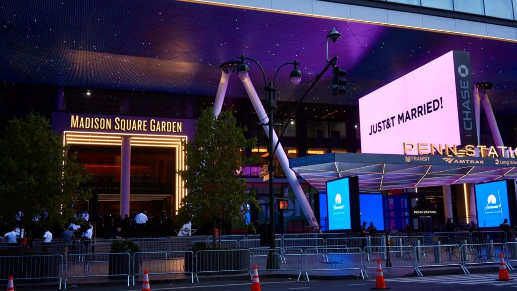 Image of a marquee lit in pink confirming marriage of Taylor Swift and Travis Kelce