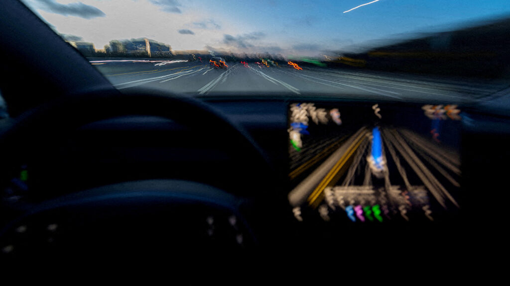 A display of a Tesla Model 3 using Full Self-Driving Supervised on a highway.