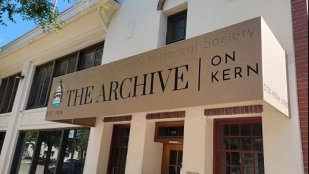 Exterior view of The Archive's gold sign and oatmeal colored pillars in downtown Fresno, California