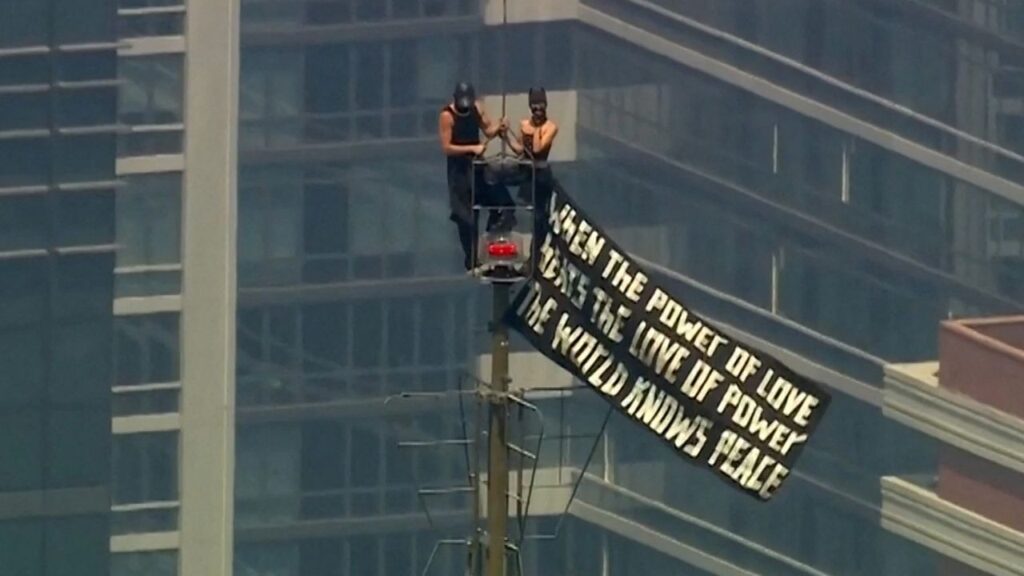 Two people display a banner atop the Empire State Building in the Manhattan borough of New York, U.S., July 1, 2026 in a still image from video. ABC Affiliate WABC/Handout via REUTERS