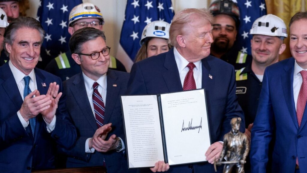 U.S. President Donald Trump holds an executive order titled "Strengthening United States National Defense with America's Beautiful Clean Coal Power Generation Fleet", next to U.S. Secretary of the Interior Doug Burgum, Speaker of the House of Representatives Mike Johnson (R-LA) and Environmental Protection Agency (EPA) Administrator Lee Zeldin, as a statue labelled "Undisputed Champion of Beautiful Clean Coal" the president received from the the Washington Coal Club stands on the table, during an event promoting coal-powered energy sources, in the East Room at the White House in Washington, D.C., U.S. February 11, 2026. REUTERS/Jonathan Ernst REFILE