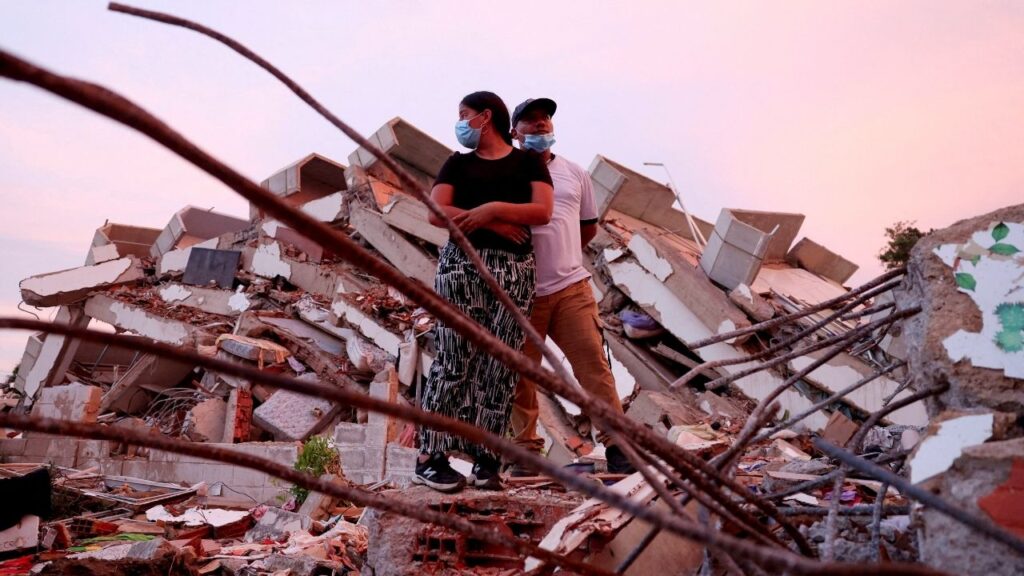 Yohancy Gil, 24 and her husband Sergio Guanipa, 30, stand on rubble as they wait for news from rescue teams looking for their children under the rubble at the site of a collapsed building in the aftermath of earthquakes, in La Guaira, Venezuela, June 30, 2026. REUTERS/Ricardo Arduengo REFILE - QUALITY REPEAT TPX IMAGES OF THE DAY