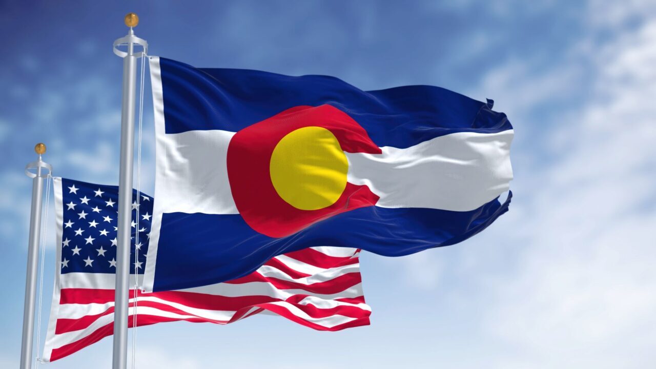 Image of the U.S. and Colorado state flags flapping in the wind